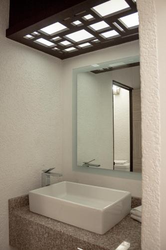 a bathroom with a large white tub and a mirror at Hotel Paseo de la Presa in Guanajuato