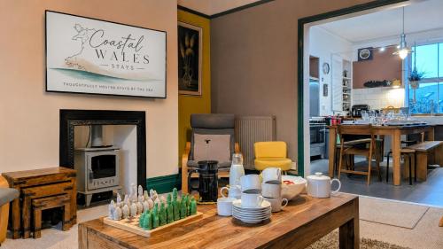 a living room with a table and a fireplace at Family Home in Tywyn - Game and Cinema Rooms in Tywyn
