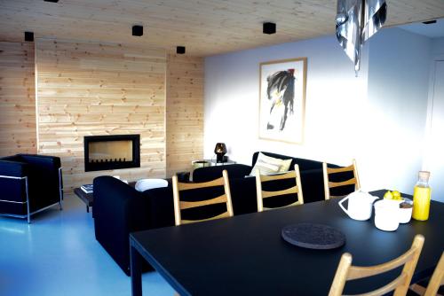a living room with a table and chairs and a couch at Home by U - Chalet 3 in Saint-Martin-de-Belleville