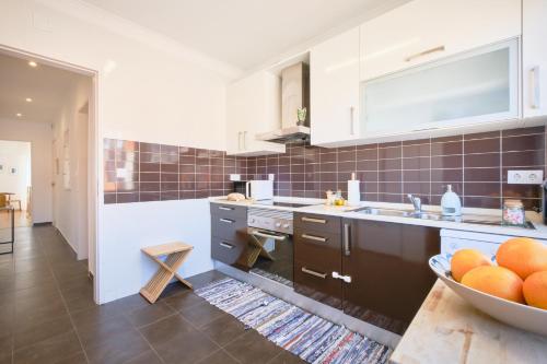 a kitchen with a bowl of oranges on a table at Dreamy Sea View Balcony in Algés