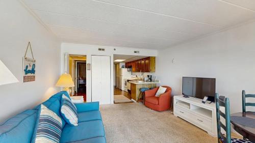 a living room with a blue couch and a television at White Marlin 105B in Ocean City