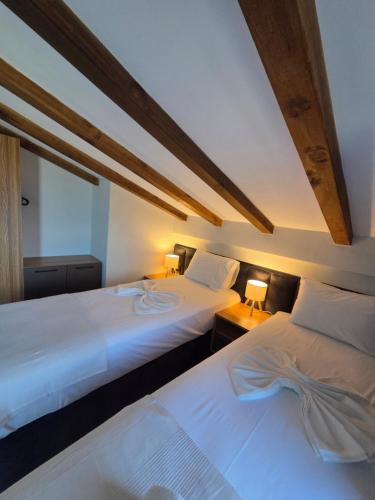 two beds sitting next to each other in a bedroom at Asteria Houses Samothraki in Samothraki