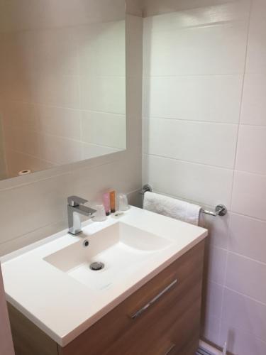 a bathroom with a white sink and a mirror at Hotel l'Avenue in Chantilly
