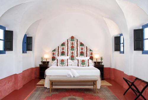 a bedroom with a bed and two tables and two lamps at Monasterio de San Francisco in Palma del Río