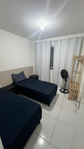 a living room with two beds and a chair at Casa Sol Nascente in Aquiraz