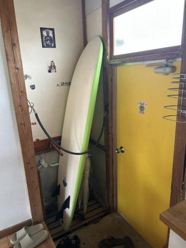 a surfboard hanging on a wall next to a door at TORAMIKE2 - Vacation STAY 53883v in Ichigaya