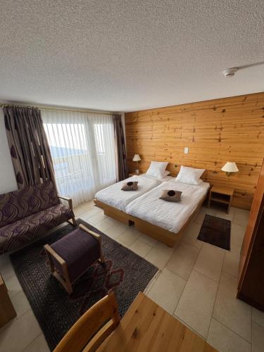 a hotel room with a bed and a chair at Cozy Studio with Wellness in Goms in Blitzingen
