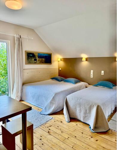 a bedroom with two beds and a table at Sodyba prie jūros in Palanga