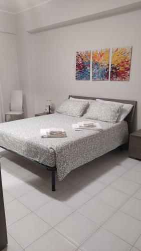 a bed in a bedroom with two paintings on the wall at Brezza dello Stretto in Mili Marina