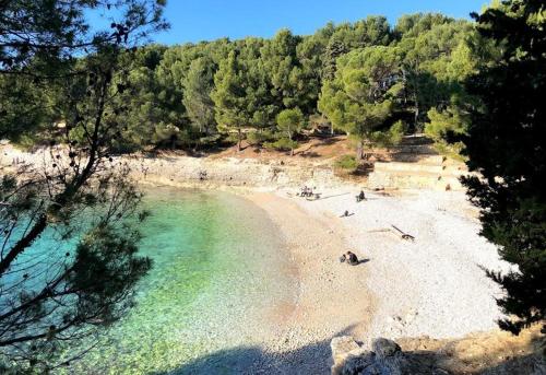 a beach with people laying on the sand and the water at Studio apartman Lea in Pula