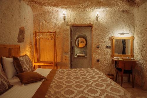 a bedroom with a bed in a stone room at Gazel Cave House in Ürgüp