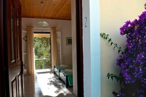 an open door to a room with purple flowers at Trifilli in Lourdata