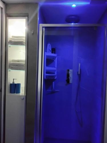 a bathroom with a shower with a blue ceiling at Suite House in Sora