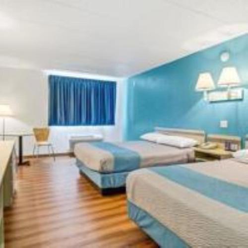 a hotel room with two beds and a blue wall at Big Springs Inn in Big Springs