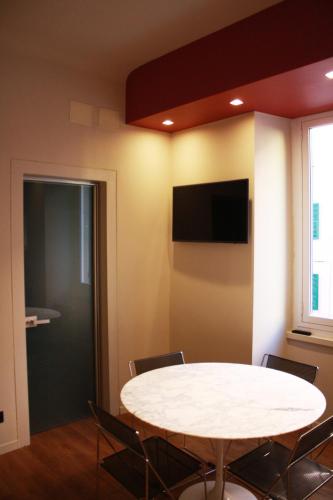 a room with a table and chairs and a tv at Le dimore di Megollo - Free Parking in Genova