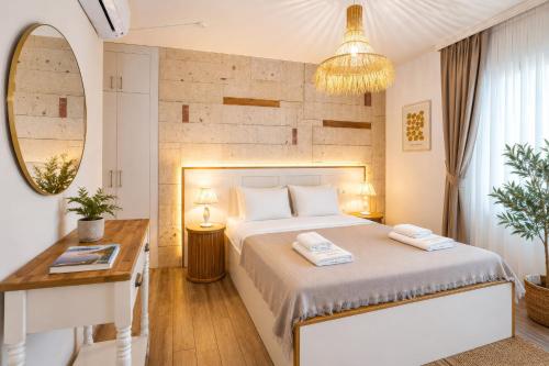 a bedroom with a bed and a desk and a mirror at Alaçatı Limonaia Hotel in Alaçatı