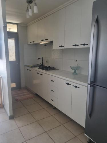 a kitchen with white cabinets and a stainless steel refrigerator at Dpto santa rosa in Ovalle