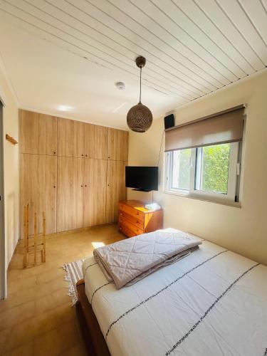 a bedroom with a large bed and a window at Grandpa’s cottage in Nea Makri