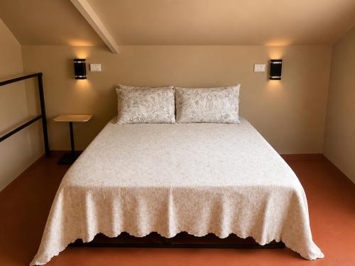 a bedroom with a large white bed with two pillows at IkI Volcán Arenal #2 in Fortuna