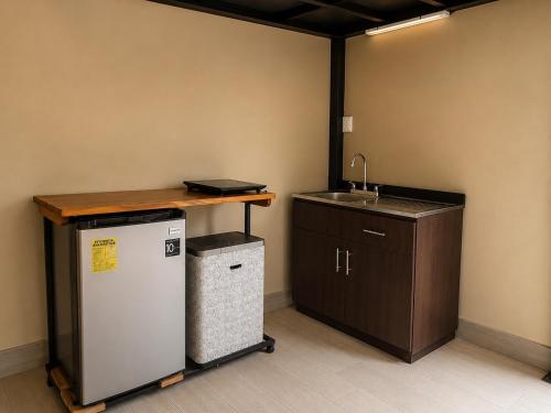 a kitchen with a counter and a sink and a refrigerator at IkI Volcán Arenal #2 in Fortuna
