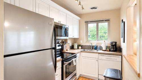 a kitchen with white cabinets and a refrigerator at Downtown 1 BR Condo near Convention Center in Seattle