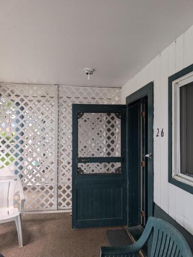 a green door in a room with a window at Lakeside Motel in Williams Lake