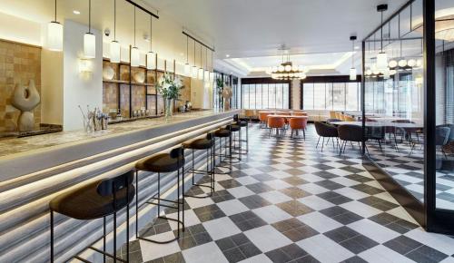 a bar in a restaurant with a checkered floor at Sercotel Pozuelo in Pozuelo de Alarcón