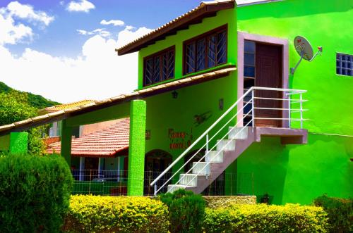 une maison verte avec un escalier en face de celle-ci dans l'établissement Hospedaria Green, à Florianópolis