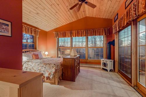 a bedroom with a bed and large windows at The Loft at Pine Rock in Weston