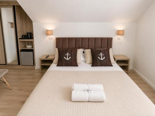 a bedroom with a large bed with towels on it at Willa Kapitańska i Willa Marynarska in Łeba