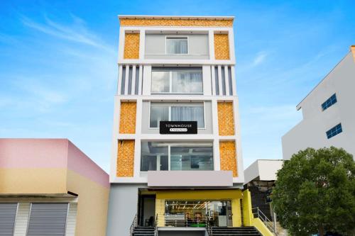a tall white building with a black sign on it at Super Townhouse Badangpet Crossway Hyderabad Formerly Balapur in Surūrnagar
