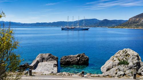a boat in a large body of water with rocks at MonemBlue in Monemvasia