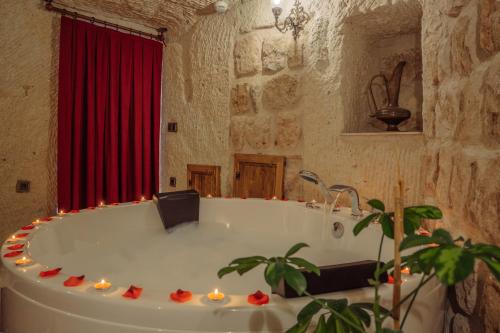 a bathroom with a tub with candles in it at Gazel Cave House in Ürgüp