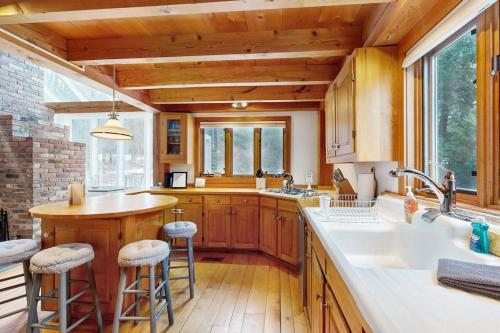 a kitchen with wooden cabinets and a kitchen island with bar stools at Whistling Peak in Wilmington