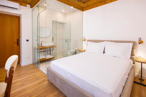 ein Schlafzimmer mit einem großen weißen Bett und ein Badezimmer in der Unterkunft Vila Violet Berat in Berat