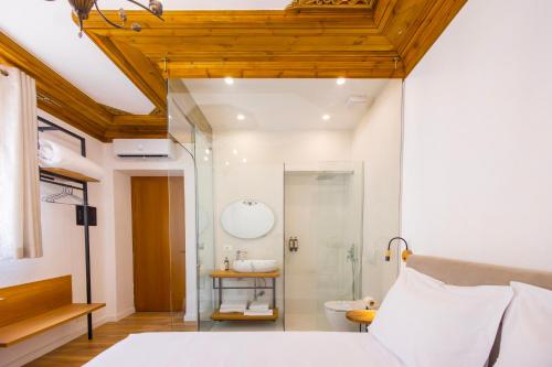 ein Schlafzimmer mit Bett, Dusche und Waschbecken in der Unterkunft Vila Violet Berat in Berat