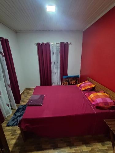 a bedroom with a large bed with purple sheets at Logis Baobab in Morondava