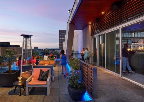 a rooftop patio with people standing on a building at The Nines, a Luxury Collection Hotel, Portland in Portland