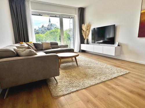 a living room with a couch and a tv at PROMENADA Apartments with FREE PARKING in Nitra