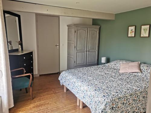 a bedroom with a bed and a cabinet at La petite FloPée in Le Mont-Saint-Adrien