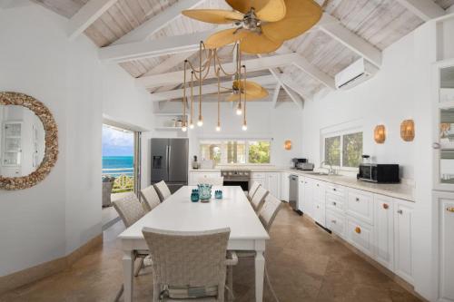 a kitchen with a dining table and a ceiling fan at Turtle Beach 5BR Snorkeling Kayaks & Family Entertainment in Providenciales
