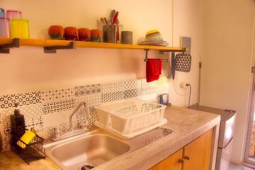 a kitchen sink with a dish drying rack above it at Casa Foto Estudios in El Cuyo
