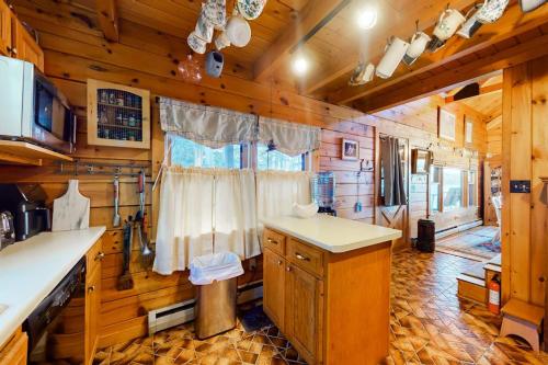 a kitchen in a cabin with wooden walls and ceilings at Lake Bomoseen Log Cabin in Bomoseen