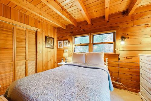 a bedroom with a bed in a wooden cabin at Lake Bomoseen Log Cabin in Bomoseen