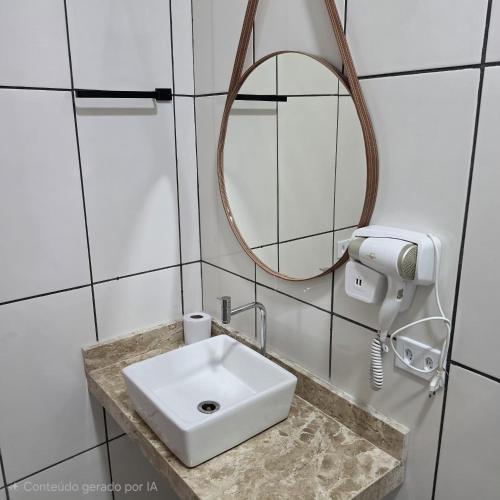 a bathroom with a white sink and a mirror at New Center Hotel in Carolina