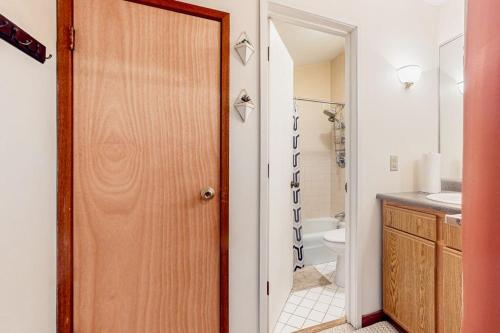 a bathroom with a toilet and a wooden door at Pico Mountain Perch, Unit B22 in Mendon