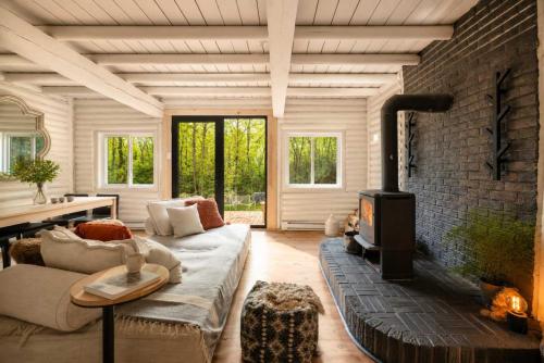 a living room with a couch and a fireplace at Sauna Forest Escape & Relaxation - Chalet Orman in Brownsburg