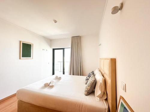 a bedroom with a large bed with a window at The Surf - Rocha Tower in Portimão
