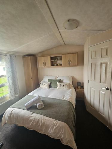 a bedroom with a large bed and a window at LuLu's Lodge, Billing Aquadrome in Northampton