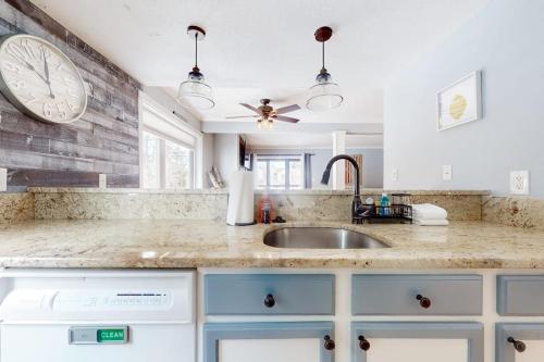 a kitchen with a sink and a clock on the wall at Ascutney Retreat in Brownsville